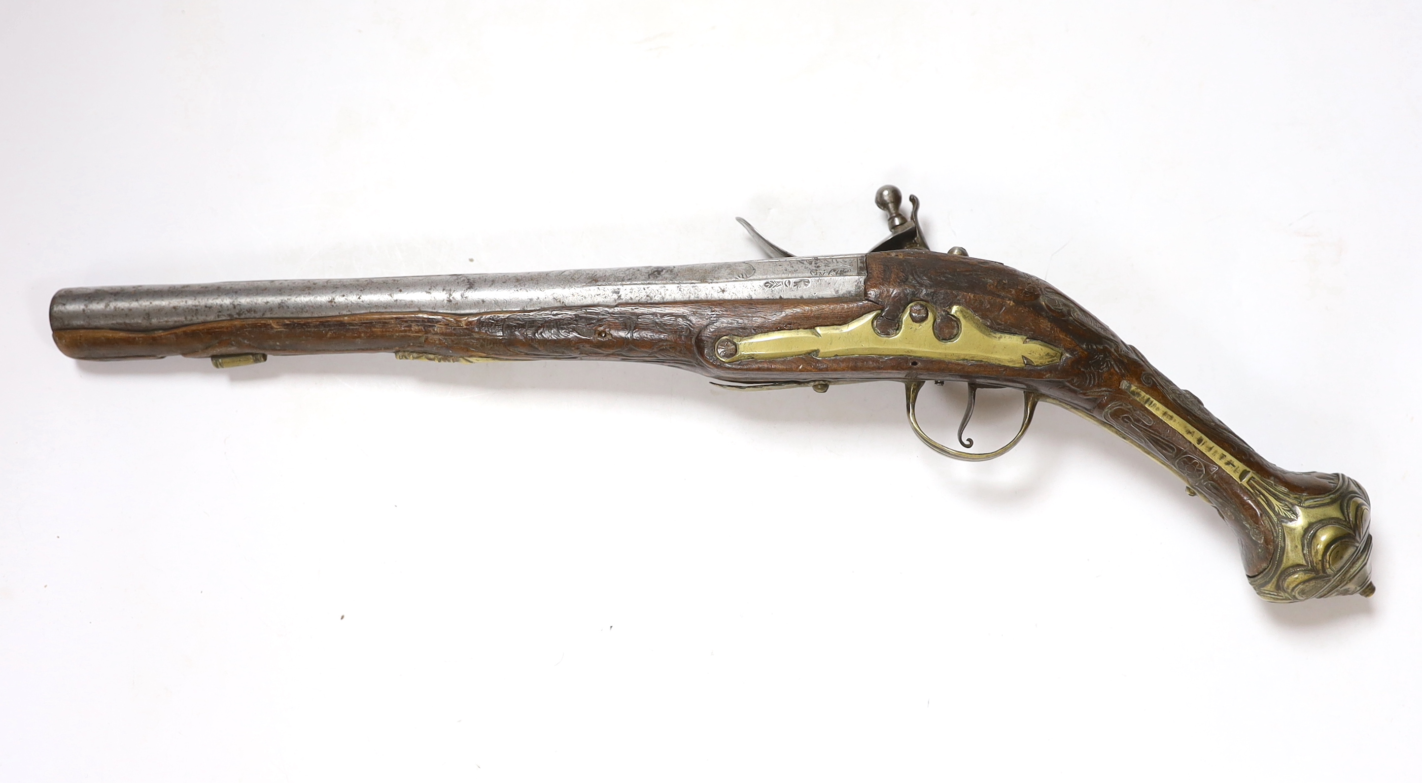 A Turkish Flintlock holster pistol with brass mounts, long spur butt cap, engraved lock and carved stock, barrel 29.5cm